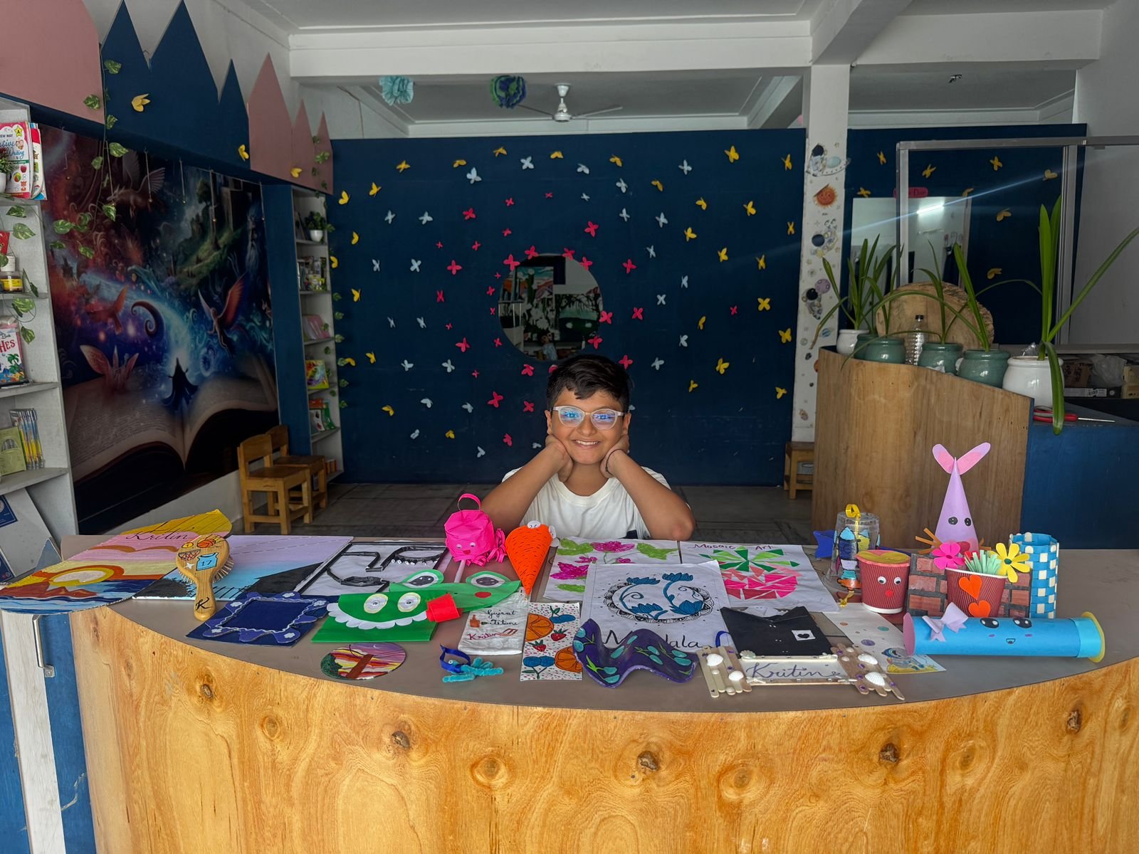 A Celestial Kids student proudly showing his art & craft creations