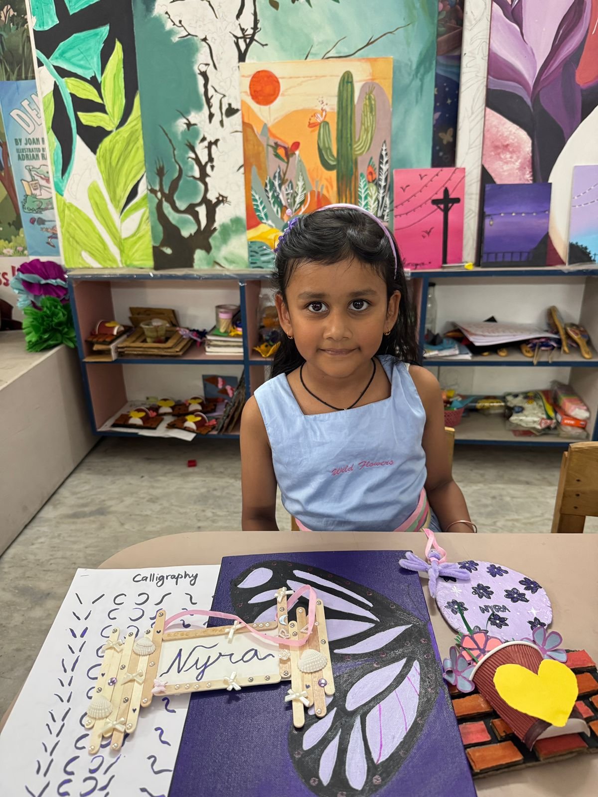 A girl with her calligraphy practice and hand-painted butterfly craft
