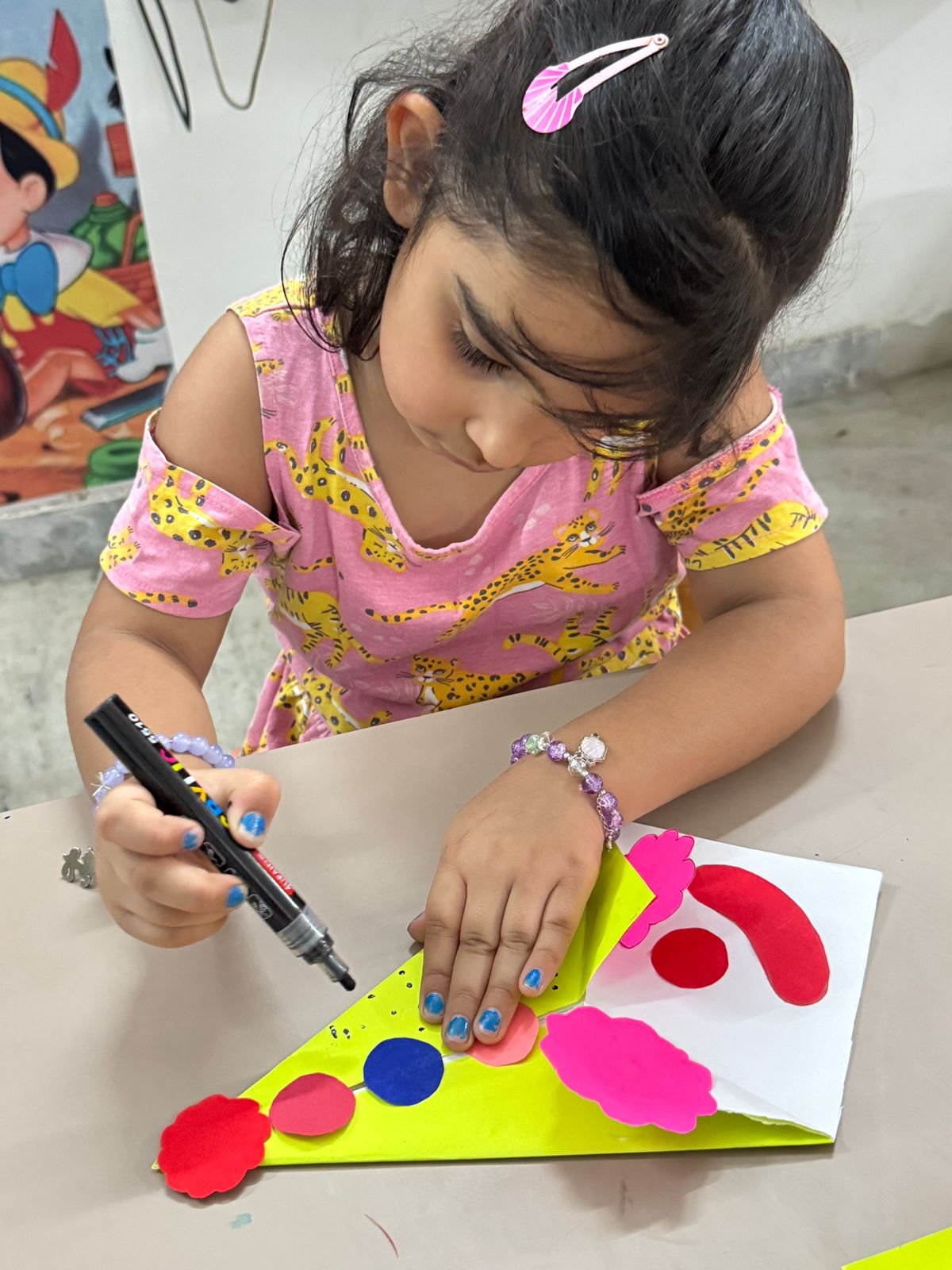 A girl focused on assembling a colourful foam shape craft